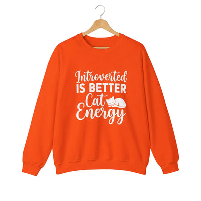 A bright orange crewneck sweatshirt featuring a white graphic text print that reads 'Introverted IS BETTER Cat Energy' with a small sleeping cat illustration.