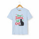 Light blue short-sleeve t-shirt on a wooden hanger with green and red text saying "Dear Santa, it was the Cat" featuring a black cat silhouette.