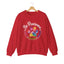 Red crewneck sweatshirt featuring a colorful paw print for cat rescue advocates with text 'Be Pawsome Adopt Foster Rescue'.