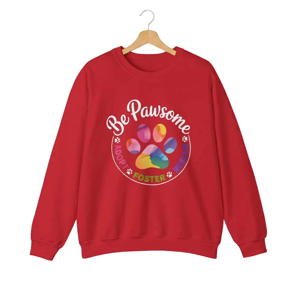 Red crewneck sweatshirt featuring a colorful paw print for cat rescue advocates with text 'Be Pawsome Adopt Foster Rescue'.