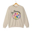 Sand crewneck sweatshirt featuring a colorful paw print for cat rescue advocates with text 'Be Pawsome Adopt Foster Rescue'.