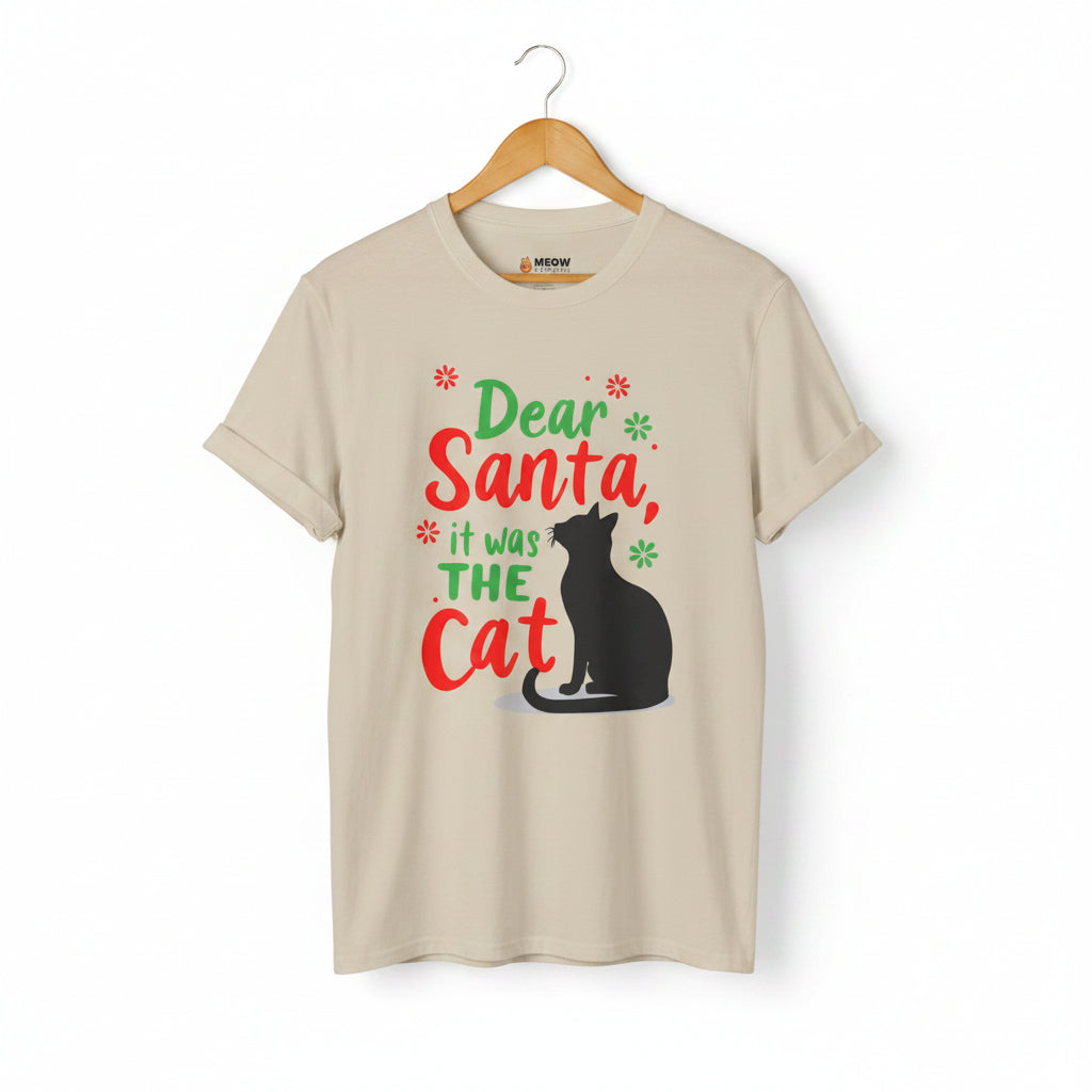 Sand short-sleeve t-shirt on a wooden hanger with green and red text saying "Dear Santa, it was the Cat" featuring a black cat silhouette.