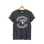 Dark heather unisex short-sleeve t-shirt with a graphic of a cartoon cat holding an American flag and the text 'STARS, STRIPES & SCRATCHES'.