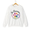 White crewneck sweatshirt featuring a colorful paw print for cat rescue advocates with text 'Be Pawsome Adopt Foster Rescue'.