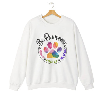 White crewneck sweatshirt featuring a colorful paw print for cat rescue advocates with text 'Be Pawsome Adopt Foster Rescue'.